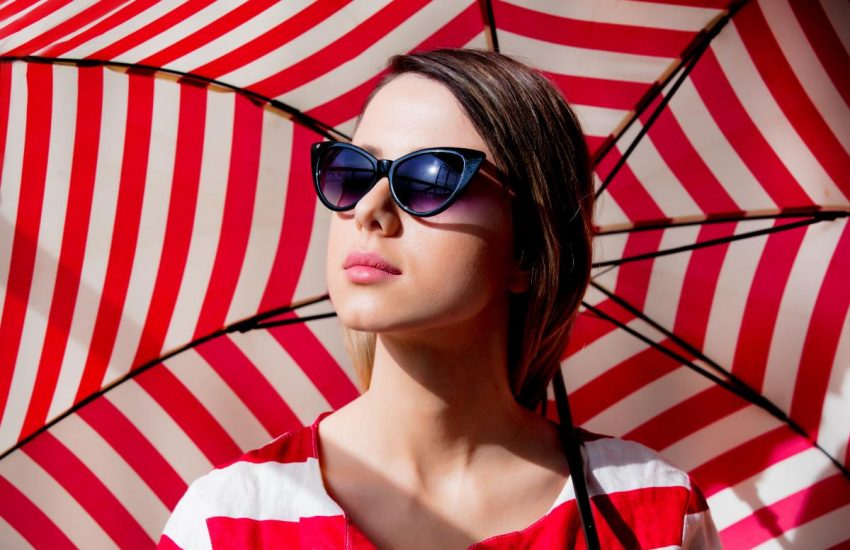Devojka sa naočarima i crveno-belim kišobranom